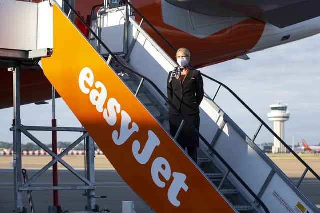 Cabin crew member Natalie Puncher wears a mask as she boards easyJet flight EZY883 before it takes-off from London Gatwick bound for Glasgow