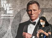 A woman walks past a poster for the new James Bond movie No Time to Die in Bangkok (Picture: Mladen Antonov/AFP via Getty Images)