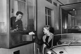 Handing over a cheque at Britain’s first drive-in bank in Liverpool in February 1958 (Picture:Keystone/Getty Images)
