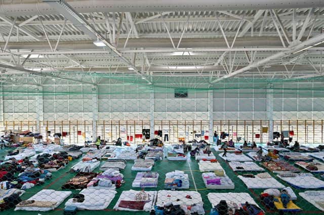 Ukrainian refugees rest at a sports arena converted into a temporary shelter in Dumbraveni, Romania (Picture: Armend Nimani/AFP via Getty Images)
