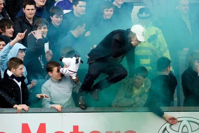 Falkirk fans try to escape flares let off by their supporters in a game with a Ross County in March 2012. (Photo by Sammy Turner/SNS Group).