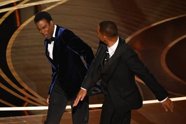 Smith (R) slaps US actor Chris Rock onstage during the 94th Oscars at the Dolby Theatre in Hollywood, California