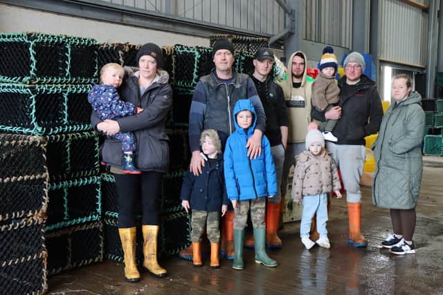Neil MacPhail and his partner Alison Campbell with their three children Eachann, Eoghan and Iain Angus, and other members of his crew with their family (Tiree Community Council)