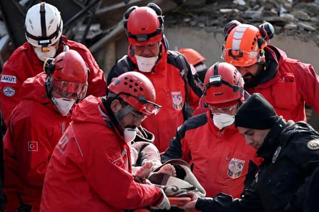 Rescuers personnel recover a body from under the rubble of collapsed buildings in Kahramanmaras, close to the quake's epicentre.