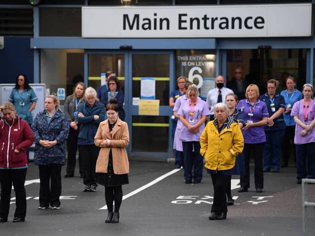 NHS workers hold a minute's silence outside the main entrance of Derriford Hospital on 28 April 2020 in Plymouth (Photo: Dan Mullan/Getty Images)