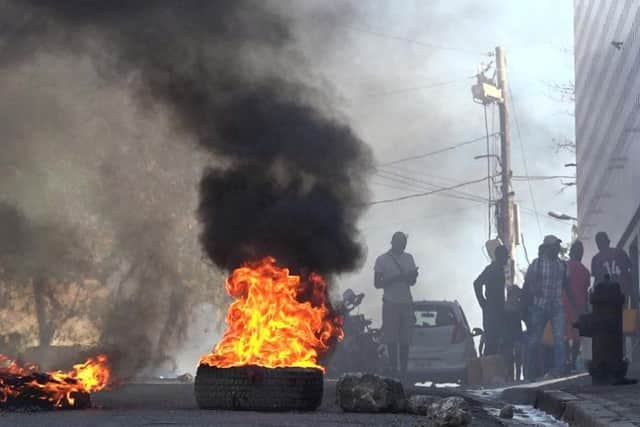 Tyres are on fire near the main prison of Port-au-Prince, Haiti, after a breakout by several thousand inmates. At least a dozen people died as gang members attacked the main prison in Haiti's capital, triggering a breakout by several thousand inmates. Picture: AFP via Getty Images