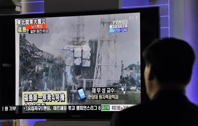 A passerby watches television news reports in South Korea about an explosion at Japan's Fukushima-Daiichi nuclear power plant after a massive earthquake and tsunami in March 2011 (Picture: Jung Yeon-Je/AFP via Getty Images)
