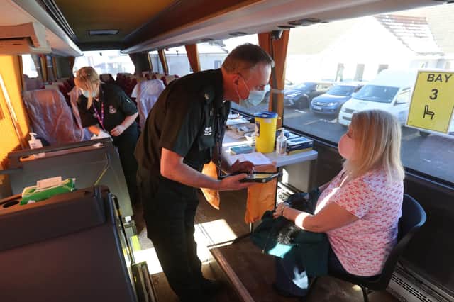 Paramedic Paul Kelly chats with June Wilson ahead of giving her a vaccine inside a holiday coach being used by the Scottish Ambulance Service outside the Culloden Medical Practice near Inverness (Picture: Andrew Milligan/PA Wire)