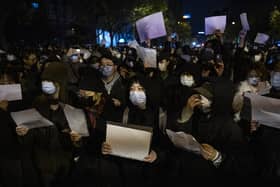 People protesting against Draconian Covid restrictions in Beijing held up blank pieces of paper to make a point about censorship (Picture: Kevin Frayer/Getty Images)