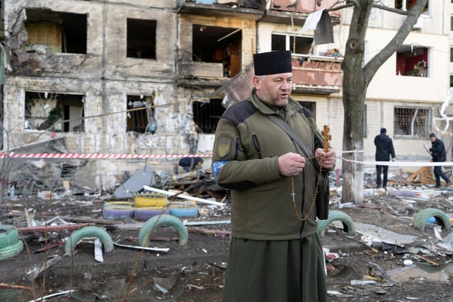 A Ukrainian military chaplain prays at the site of a fire caused by pieces of a fallen Russian missile in Kyiv's Obolon district. 
Photojournalist Bennett Murray captured scenes on March 14 in Obolon district, Kyiv, Ukraine.