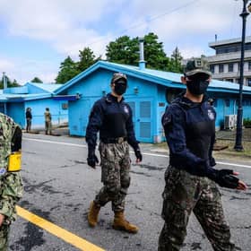 A United Nations Command soldier and South Korean soldiers walk in the Joint Security Area of the Demilitarized Zone in the truce village of Panmunjom. North Korea fired a mid-range ballistic missile on October 4, which flew over Japan, Seoul and Tokyo said, a significant escalation as Pyongyang ramps up its record-breaking weapons-testing blitz.