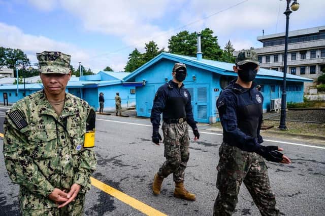A United Nations Command soldier and South Korean soldiers walk in the Joint Security Area of the Demilitarized Zone in the truce village of Panmunjom. North Korea fired a mid-range ballistic missile on October 4, which flew over Japan, Seoul and Tokyo said, a significant escalation as Pyongyang ramps up its record-breaking weapons-testing blitz.