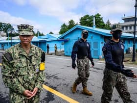 A United Nations Command soldier and South Korean soldiers walk in the Joint Security Area of the Demilitarized Zone in the truce village of Panmunjom. North Korea fired a mid-range ballistic missile on October 4, which flew over Japan, Seoul and Tokyo said, a significant escalation as Pyongyang ramps up its record-breaking weapons-testing blitz.