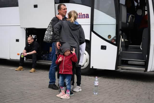 A young girl hides under her mother's coat as refugees from the war torn regions of Ukraine board a coach in Lviv, Ukraine. Picture: Getty Images