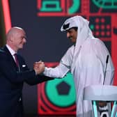 FIFA President Gianni Infantino (left) greets Qatar's Emir Sheikh Tamim bin Hamad al-Thani during the draw for the 2022 World Cup at the Doha Exhibition and Convention Center on April 1, 2022. (Photo by FRANCK FIFE/AFP via Getty Images)