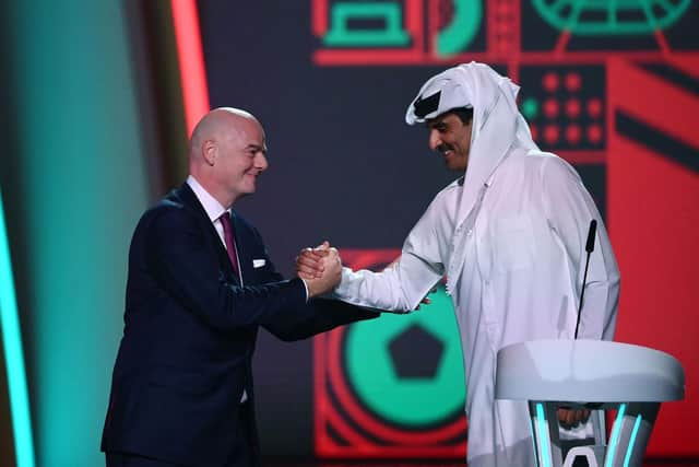 FIFA President Gianni Infantino (left) greets Qatar's Emir Sheikh Tamim bin Hamad al-Thani during the draw for the 2022 World Cup at the Doha Exhibition and Convention Center on April 1, 2022. (Photo by FRANCK FIFE/AFP via Getty Images)