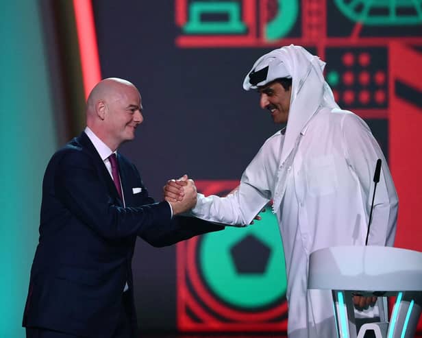 FIFA President Gianni Infantino (left) greets Qatar's Emir Sheikh Tamim bin Hamad al-Thani during the draw for the 2022 World Cup at the Doha Exhibition and Convention Center on April 1, 2022. (Photo by FRANCK FIFE/AFP via Getty Images)