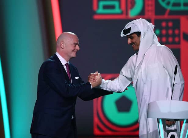 FIFA President Gianni Infantino (left) greets Qatar's Emir Sheikh Tamim bin Hamad al-Thani during the draw for the 2022 World Cup at the Doha Exhibition and Convention Center on April 1, 2022. (Photo by FRANCK FIFE/AFP via Getty Images)