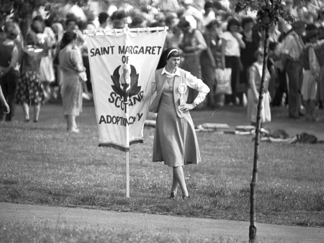 A nun holds the Saint Margaret of Scotland Adoption Agency banner during the Mass at Bellahouston Park.