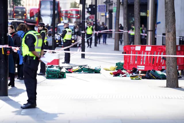 Police officers at the scene after three people have been taken to hospital following reports of stabbings at Bishopsgate in London.