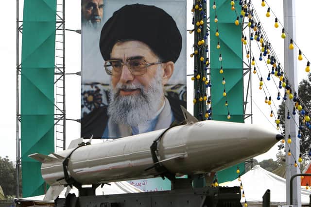 An unidentified Iranian missile in front of a large portrait of Iran's Supreme Leader Ayatollah Ali Khamenei in a square in south Tehran (Picture: Atta Kenare/AFP via Getty Images)