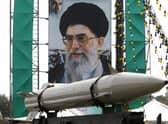 An unidentified Iranian missile in front of a large portrait of Iran's Supreme Leader Ayatollah Ali Khamenei in a square in south Tehran (Picture: Atta Kenare/AFP via Getty Images)