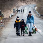 A woman with two children walk towards the border with Slovakia near the Ukrainian city of Welykyj Beresnyj following the Russian invasion (Picture: Peter Lazar/AFP via Getty Images)