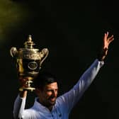 Serbia's Novak Djokovic poses with his trophy after defeating Australia's Nick Kyrgios during the men's singles final tennis match.