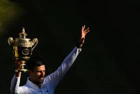Serbia's Novak Djokovic poses with his trophy after defeating Australia's Nick Kyrgios during the men's singles final tennis match.