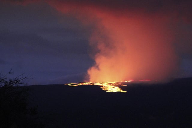 Mauna Loa, the world's largest active volcano,  began spewing ash and debris from its summit, prompting civil defense officials to warn residents on Monday to prepare in case the eruption causes lava to flow toward communities. (Chelsea Jensen/West Hawaii Today via AP)