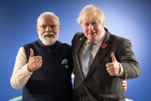 Prime Minister Boris Johnson (right) greets India's Prime Minister Narendra Modi ahead of pledges to end deforestation and have India set a net-zero emissions target.