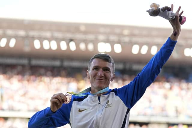 Jake Wightman of Scotland poses on the podium after winning the bronze medal in the Men's 1500 meters during the athletics competition in the Alexander Stadium at the Commonwealth Games in Birmingham, England, Saturday, Aug. 6, 2022. (AP Photo/Alastair Grant)