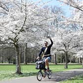 A man cycles past cherry blossom trees in Battersea Park, in London. Photo by JUSTIN TALLIS / AFP/ Getty