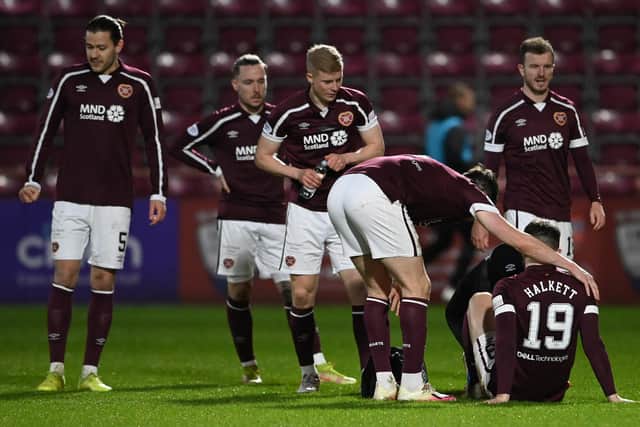 Hearts Craig Halkett goes down injured against Ross County.