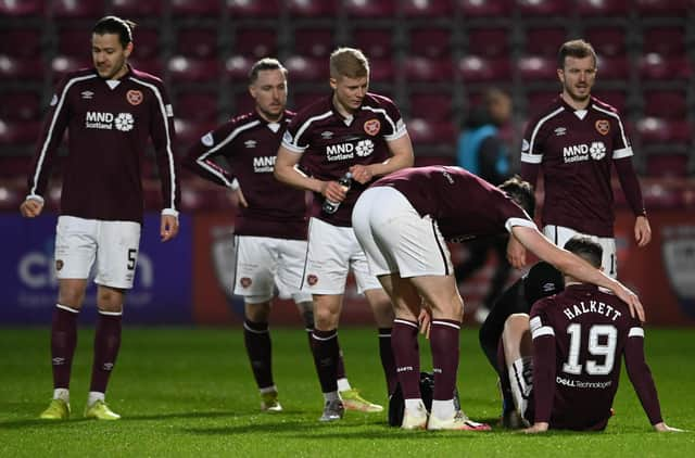 Hearts Craig Halkett goes down injured against Ross County.