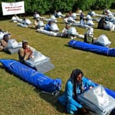 Flood-affected people sit along with their relief supplies being distributed by the International Federation of Red Cross in Jaffarabad district, Balochistan province.