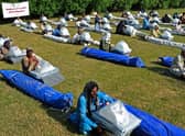 Flood-affected people sit along with their relief supplies being distributed by the International Federation of Red Cross in Jaffarabad district, Balochistan province.
