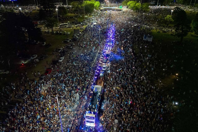 This aerial image taken on December 20, 2022 shows Argentina's players celebrating on board a bus with supporters after winning the Qatar 2022 World Cup tournament as they leave Ezeiza International Airport en route to the Argentine Football Association (AFA) training centre in Ezeiza, Buenos Aires province, Argentina. (Photo by Tomas CUESTA / AFP) (Photo by TOMAS CUESTA/AFP via Getty Images)