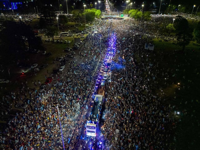 This aerial image taken on December 20, 2022 shows Argentina's players celebrating on board a bus with supporters after winning the Qatar 2022 World Cup tournament as they leave Ezeiza International Airport en route to the Argentine Football Association (AFA) training centre in Ezeiza, Buenos Aires province, Argentina. (Photo by Tomas CUESTA / AFP) (Photo by TOMAS CUESTA/AFP via Getty Images)