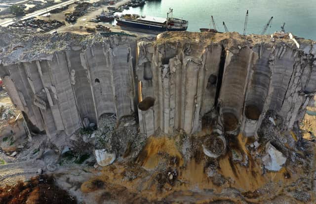 Rubble, spilled grains remain around towering silos gutted in the massive August explosion at the Beirut port that claimed the lives of more than 200 people, in Beirut, Lebanon (AP Photo/Hussein Malla).