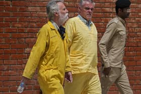 Jim Fitton of Britain, left, and Volker Waldman  escorted by Iraqi security forces, outside a courtroom, in Baghdad