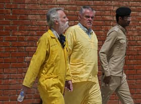Jim Fitton of Britain, left, and Volker Waldman  escorted by Iraqi security forces, outside a courtroom, in Baghdad