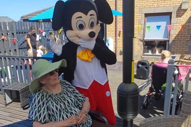 Resident with Mickey Mouse at HC-One Scotland’s Merino Court Care Home at Summer Fete