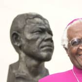 Desmond Tutu, pictured with a bust of former South African president Nelson Mandela in 2001, has died aged 90 (Picture: William Conran/PA)