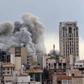 A plume of smoke rises after a strike in Tehran, Iran. 