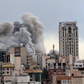 A plume of smoke rises after a strike in Tehran, Iran. 