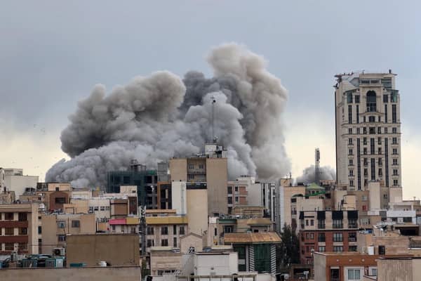 A plume of smoke rises after a strike in Tehran, Iran. 