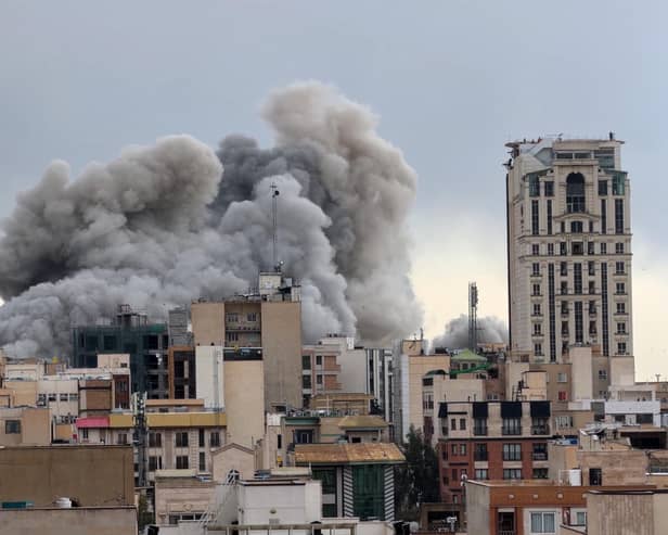 A plume of smoke rises after a strike in Tehran, Iran. 