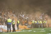 Dundee United fans throw a smoke bomb on the pitch during a cinch Premiership match against Ross County.
