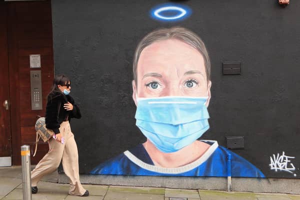 A woman walks past a mural in Manchester city centre.